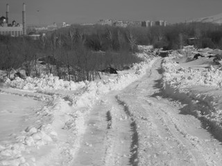 Ust-Kamenogorsk (Kazakhstan). Snowy country road. Winter steppe. City outskirts. Black and White