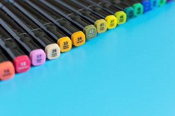Multi-colored markers on a blue background. Marker for drawing and creativity
