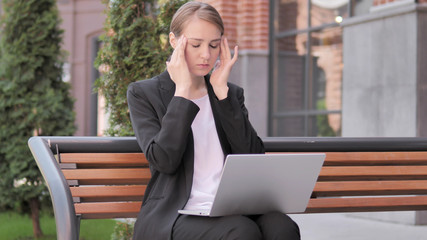 Sitting Outdoor Young Businesswoman with Headache Using Laptop