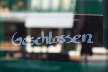 Geschlossen Schild hinter Eingangstür im Geschäft