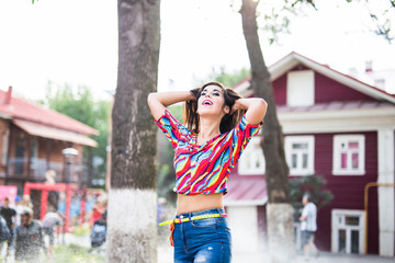 Beautiful attractive young woman having fun and enjoying and dancing in the park on a sunny summer day.