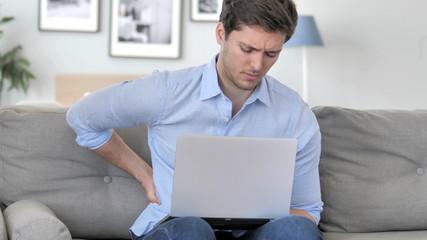 Spinal Back Pain while Handsome Young Man Working in Creative Office
