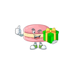 Cheerful strawberry macarons cartoon character holding a gift box