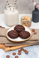 Obraz na płótnie Canvas Chocolate cookies with choco drops on white plate, and glass of milk