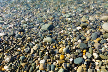 Pebble beach. Sea view. Sea shore with calm clear water