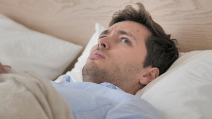 Fototapeta na wymiar Uncomfortable Man Waking up from Sleep in Bed