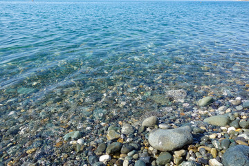 Pebble beach. Sea view. Sea shore with calm clear water