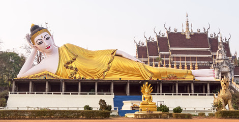 Ancient Buddhist temple complex with a statue of Reclining Buddha in Thailand