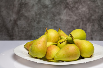 Ripe and juicy pears on the table with drops of water.