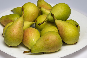 Ripe and juicy pears on the table with drops of water.