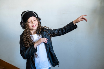 girl in black headphones listens to music in the porch of the house