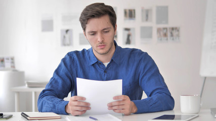 Young Man Rearing Contract Carefully, Paperwork