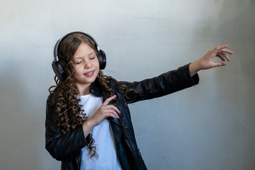 girl in black headphones listens to music in the porch of the house