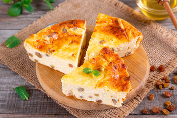 Cheese casserole with raisins on plate on wooden table