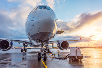 Airplane before flight, aircraft maintenance at the airport. Sunset at the aerodrome.