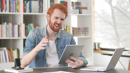 Upset Young Casual Redhead Man Facing Loss on Tablet