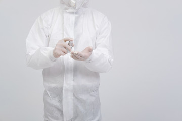man scientist wearing biological protective uniform suit clothing, mask, gloves with hand sanitizer dispenser for sanitizing virus bacteria