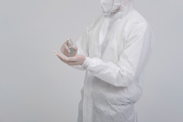 man scientist wearing biological protective uniform suit clothing, mask, gloves with hand sanitizer...
