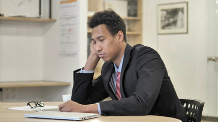 Fototapeta na wymiar Tired Young African Businessman Sleeping at Work