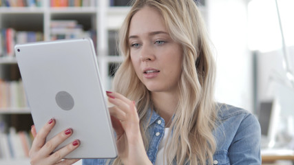 Young Blonde Woman Browsing Internet on Tablet