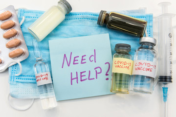 coronavirus epidemic concept. medical face mask with a red inscription COVID-19 and syringe with possible found vaccine