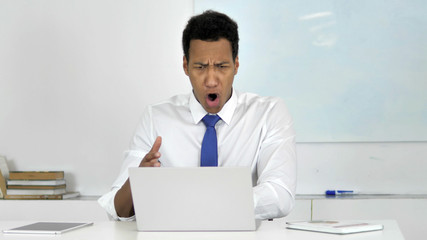 Angry Afro-American Businessman in Anger and Frustration Working on Laptop