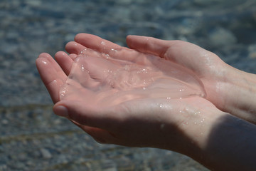 Jellyfish in the hands on the background of sea water