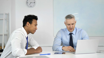 Obraz premium Mixed Race Businessmen Discussing Project in Office