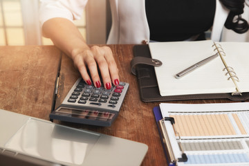 Business woman accountant or banker using calculator in retro office. Savings, finances and economy...