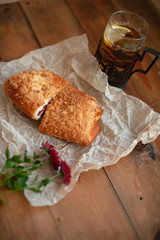 Freshly baked appetizing bun and tea on the board