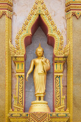 Golden Buddhist statues in a temple in an Asian country.