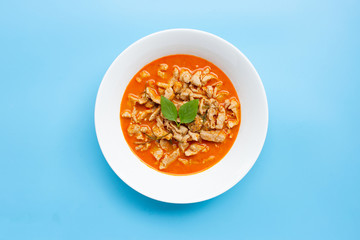 Panaeng Curry with chicken  in white bowl on blue background.