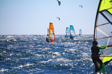 Windsurfers at the Atlantic ocean and youngster in front in bokeh