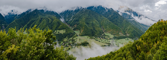 Fototapeta na wymiar Summer mountains green forest and blue sky with clouds landscape. Aerial panoramic photo of Caucasian mountains, top view. Travel and vacation concept.
