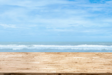 light brown wood table on blurred seascape background