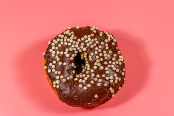 Tasty chocolate donut on a pink background