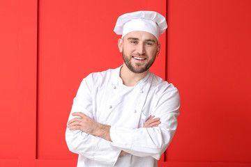 Handsome male chef on color background