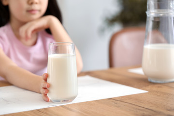 Cute Asian girl with milk at home