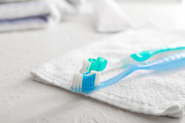 Tooth brushes and towel on table