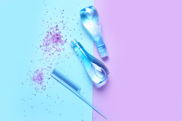 Shampoo, comb and sea salt on color background