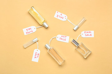 Bottles of perfumes for sale on color background