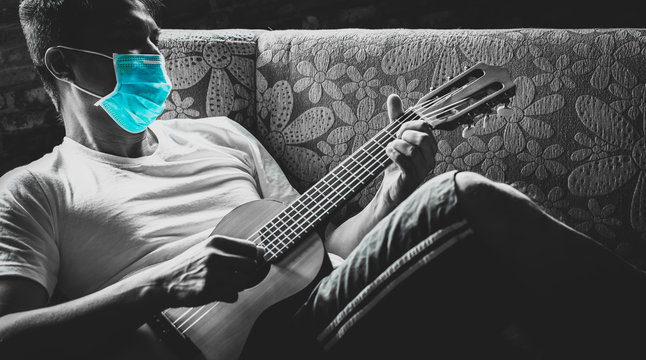asian man at risk of infection in coronavirus covid 19 playing guitar for relaxation while quarantine himself at home to prevent outbreak