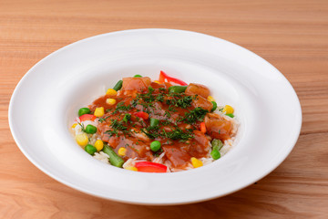 Rice with beef stew with green beans and vegetables served in white plate over light rustic wooden table.