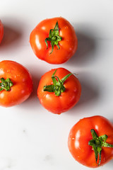 Fresh ripe tomatoes on light marble background. Summer organic vegetable for salad