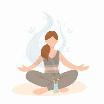 Young woman sitting in lotus pose with aroma diffuser. Aromatherapy and relax. Self care at home. - 