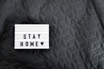 Lightbox with Stay home text on wooden background. Top view flat lay Covid-19 quote