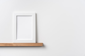 vertical white wood photo on bookshelf and wall