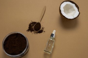 top view homemade scrub diy kit, coconut oil and ground coffee beans on a brown background