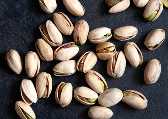 Roasted pistachios nuts on dark background. Healthy snack