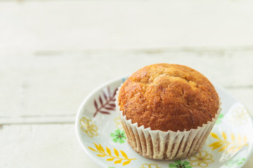 Close up banana cake on white plate on wooden table, blank left side for copy space.